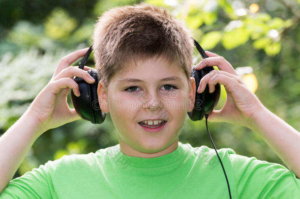 在公园里用耳机<strong>听音乐的男孩</strong>