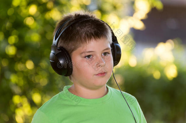 在公园里用耳机<strong>听音乐的男孩</strong>