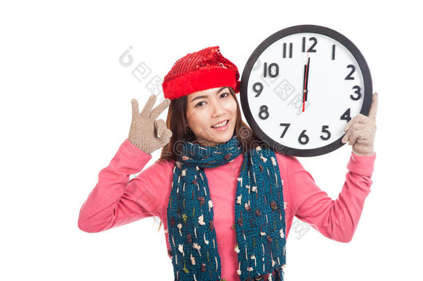 午夜时分，亚洲女孩戴着红色圣诞帽和时钟走秀
