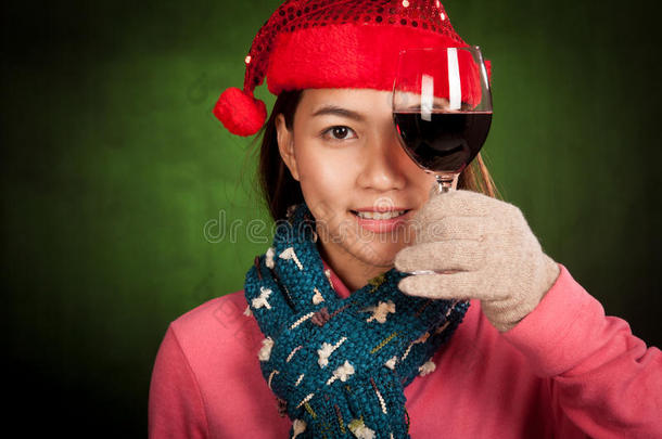 带着红色圣诞帽的亚洲女孩<strong>展示红酒</strong>
