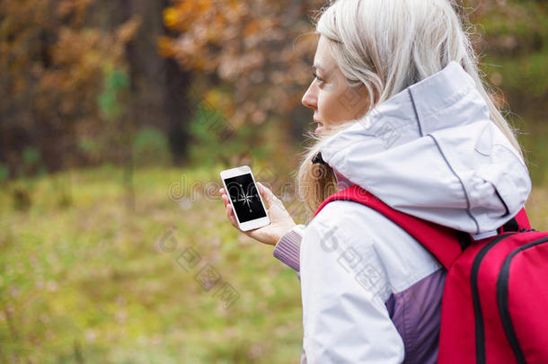 一位女士在智能手机上查看指南针应用程序