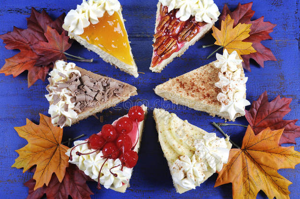 在深蓝色的木头上放着秋天的叶子的感恩节馅饼。