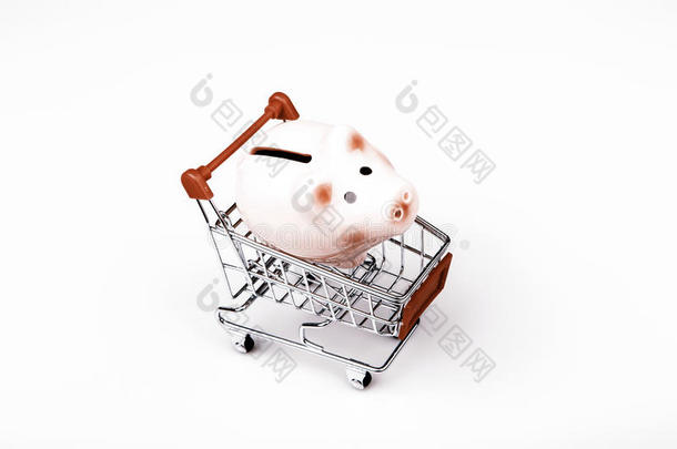 白色背景的购物车里的猪钱箱