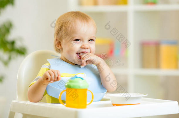 快乐的小男孩用勺子吃自己