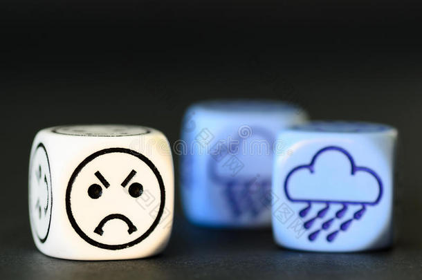 阴雨天气的概念-黑色背景上的表情符号和天气骰子