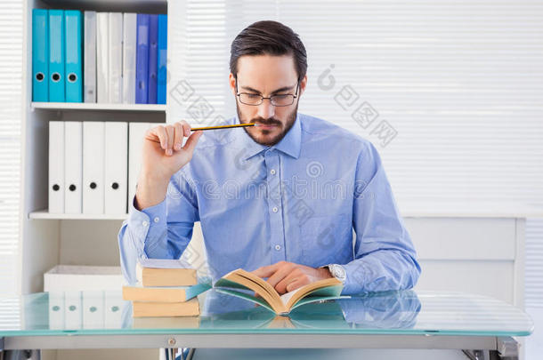 <strong>专注</strong>的商人在书桌边看书