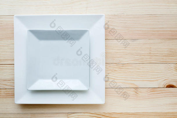 木制桌子上的白色方形盘子
