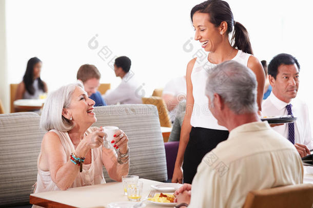 酒店餐厅为老年夫妇提供早餐的女服务员
