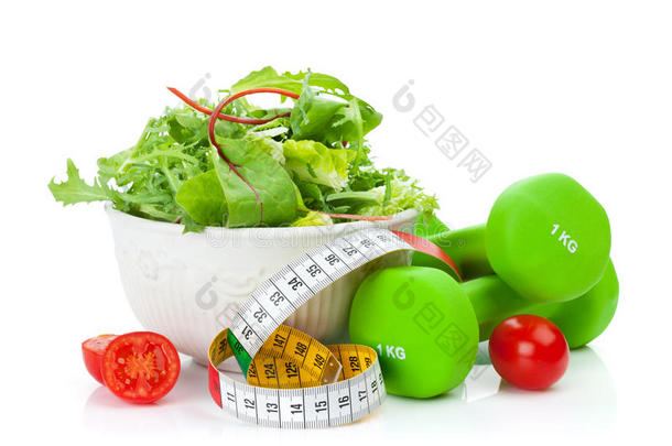 两个绿色的哑铃，卷尺和健康食品。健康与健康
