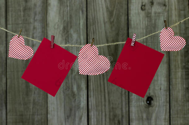 红色的纸牌和红白相间的红白相间的红心挂在晾衣绳上，有着古色古香的木质背景