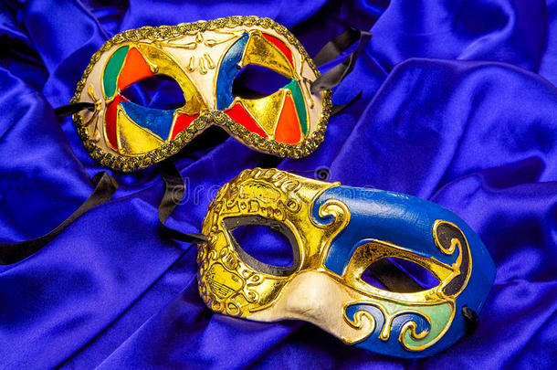 两个蓝色丝绸上的彩色狂欢节面具