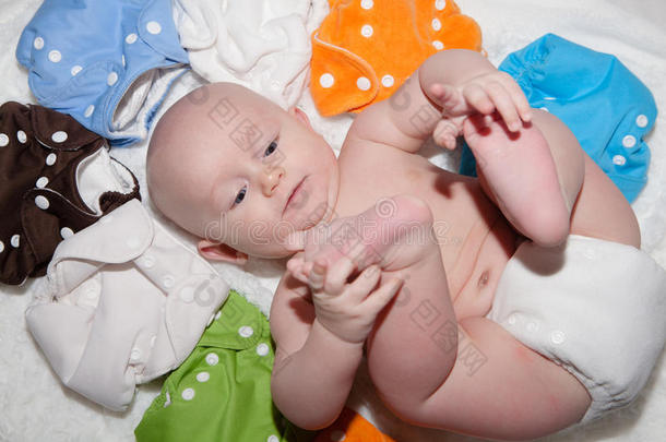 宝宝穿着一个布尿布被彩虹般的布尿布包围