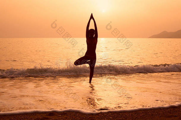 一个女孩在海滩上练习<strong>瑜伽</strong>的<strong>剪影</strong>
