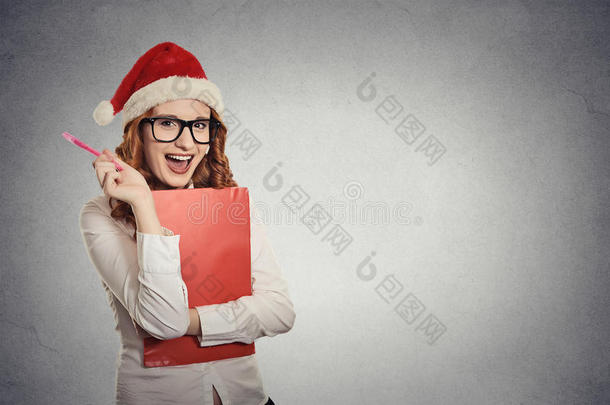 戴着圣诞帽的女人在摄影棚摆姿势，想着礼物的<strong>点子</strong>