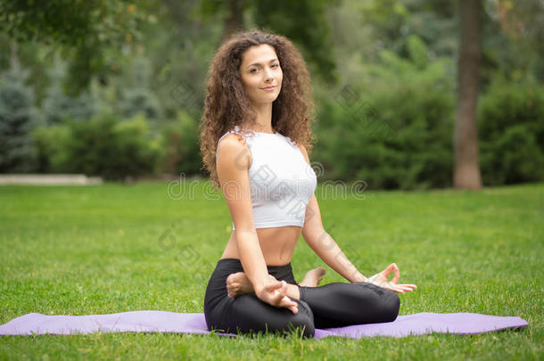 美丽的女人在莲花里做瑜伽冥想