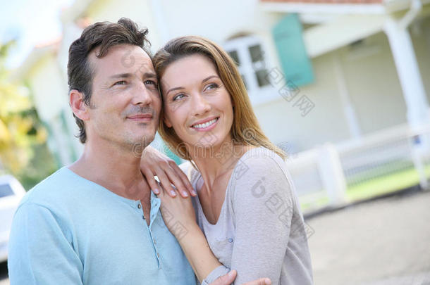 一对恩爱夫妻在屋前微笑的画像