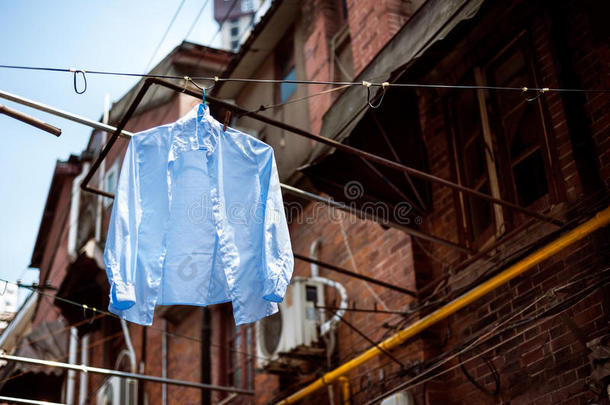 在<strong>上海老</strong>城区的一条传统小巷里，蓝色衬衫挂在晾衣绳上