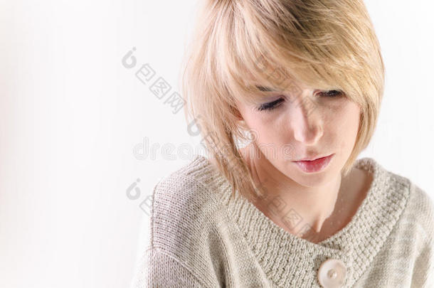 金发年轻女人穿着白色的大羊绒衫