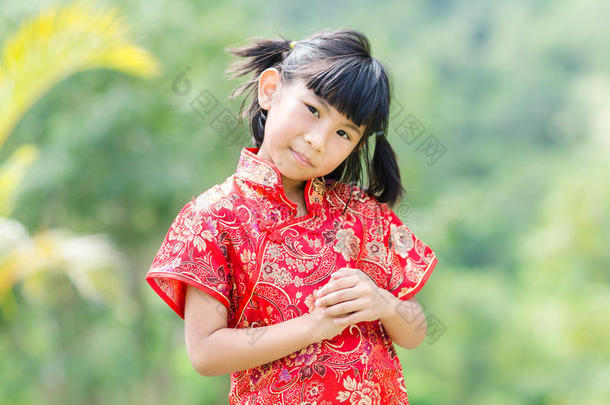 有自然背景的<strong>中国传统</strong>旗袍的亚洲孩子。