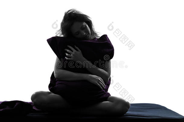 女人睡意抱枕坐在床上剪影