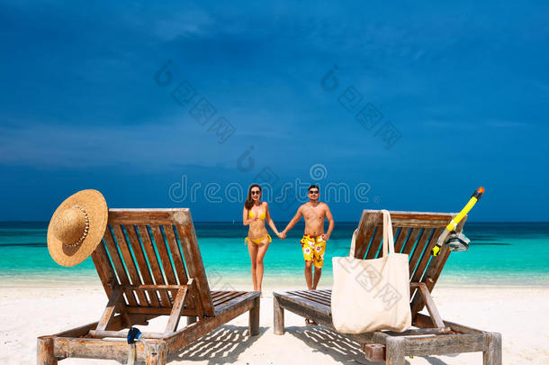 一对穿<strong>黄衣</strong>服的夫妇在马尔代夫的海滩上奔跑