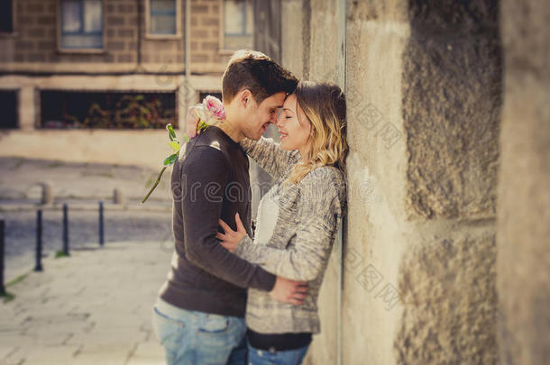 一对美丽的欧洲情侣在街头小巷亲吻玫瑰庆祝情人节