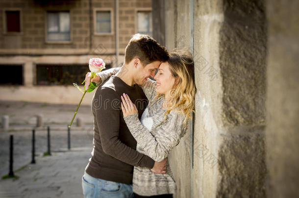 一对美丽的欧洲情侣在街头小巷亲吻玫瑰庆祝情人节