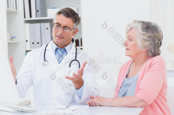 医生在电脑上向病人解释报告