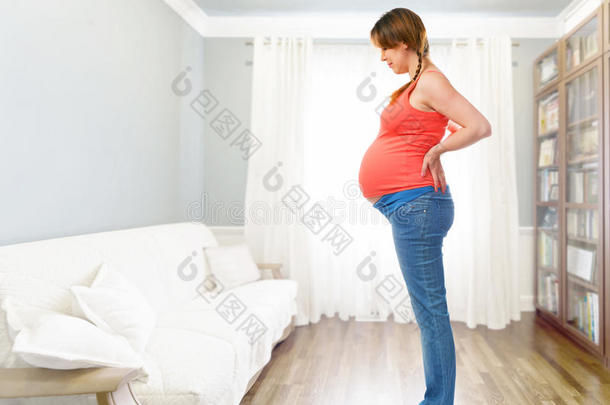 一个可爱的孕妇站在秤上