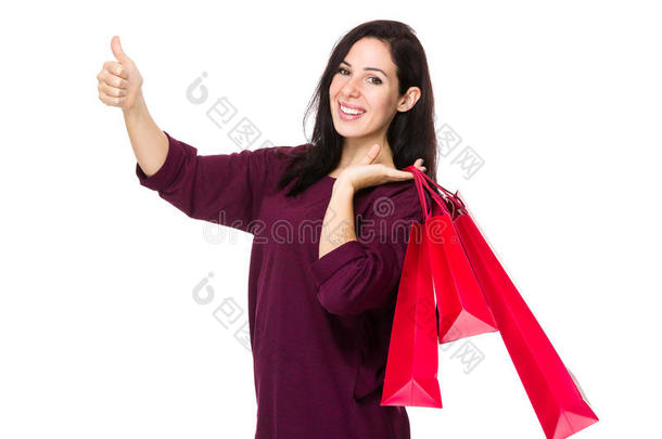 女人拿着购物袋，大拇指朝上