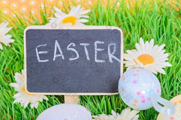 复活节鸡蛋和黑板在草地上