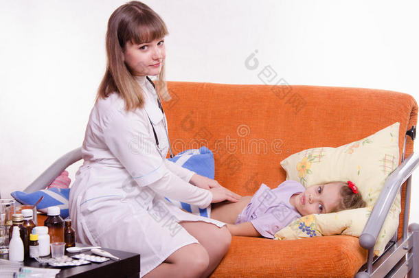 医生握住一个小女孩的腹部触诊