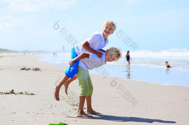 积极的海滩美丽的男孩兄弟情谊