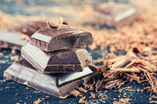 巧克力。 黑巧克力。 几块黑巧克力加薄荷叶。 巧克力板从磨碎的巧克力粉中溢出