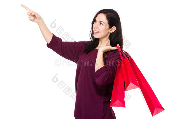 黑发女人拿着<strong>购物</strong>袋，手指指着