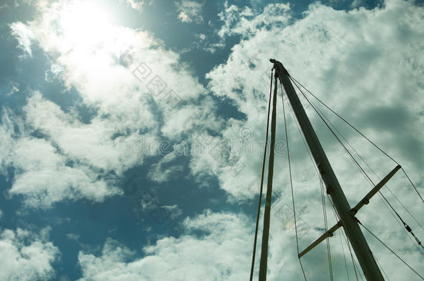 游艇桅顶着夏日蔚蓝的天空。游艇