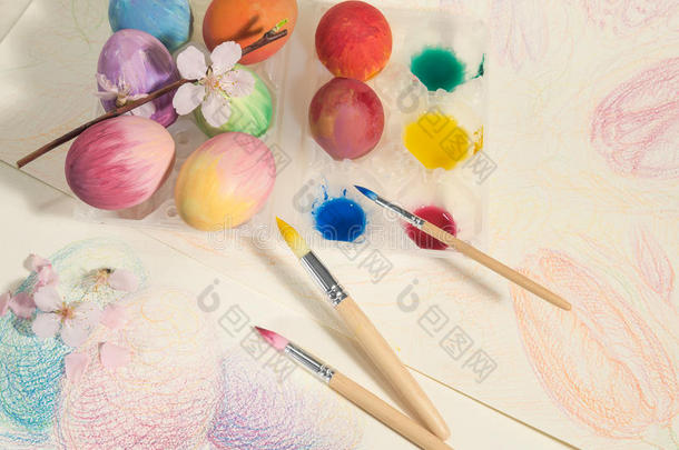 复活节手绘鸡蛋与油漆刷，水彩和杏仁花，安排在一幅彩色画上。