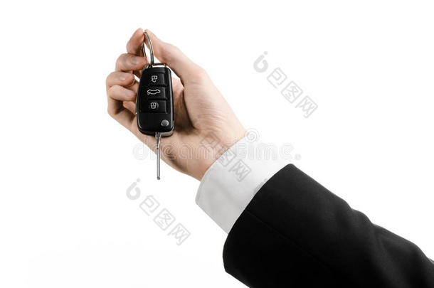 业务主题：<strong>汽车销售</strong>员穿着黑色西装，拿着一把汽车钥匙，在白色背景上隔离