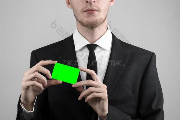 商人穿着<strong>黑色</strong>西装和<strong>黑色</strong>领带拿着一张<strong>卡</strong>片，一只手拿着一张<strong>卡</strong>片，绿<strong>卡</strong>，<strong>卡</strong>片被插入，绿色的色度