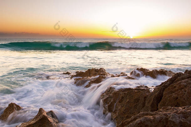 清晨的海洋景观在岩石海岸上，闪闪发光