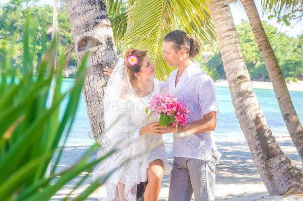 新娘和新郎，年轻的爱的夫妇，在他们的婚礼日，户外海滩婚礼在热带海滩和海洋背景