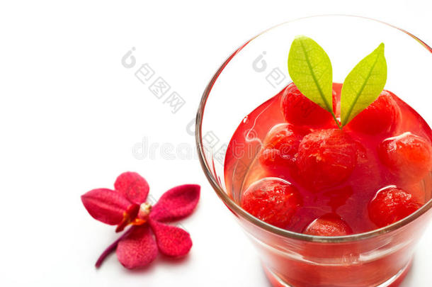 玻璃美味的<strong>清爽</strong>饮料充满活力的西瓜与红色兰花在白色的背景