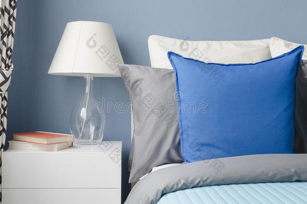 蓝色枕头在床上，玻璃灯在白色桌子上，现代蓝色