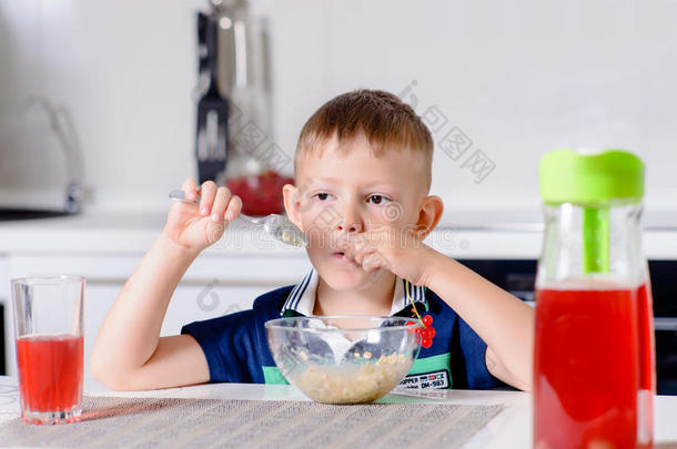 男孩早餐时吃燕麦粥