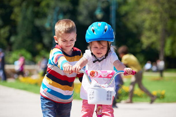 公园里的男孩和女孩学习骑自行车