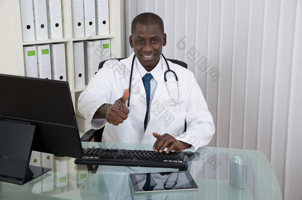 医生在前台的前台电脑前竖起大拇指