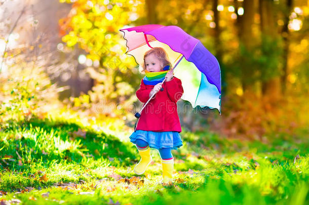 秋天公园里，孩子在雨中打伞