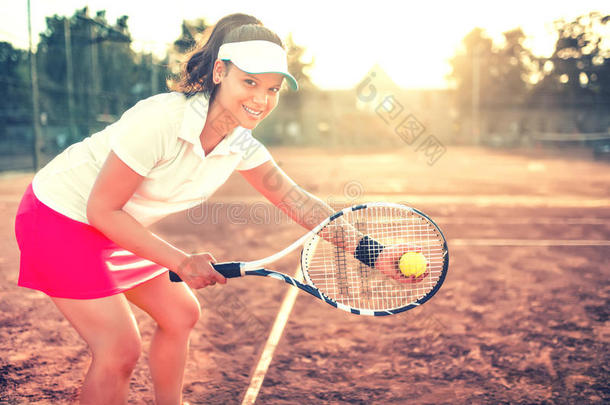 黑发女孩用球拍、球和运动设备打网球。 在网球车上特写美女的肖像