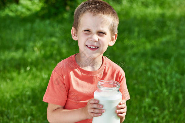 阳光明媚的花园里有一壶牛奶的男孩