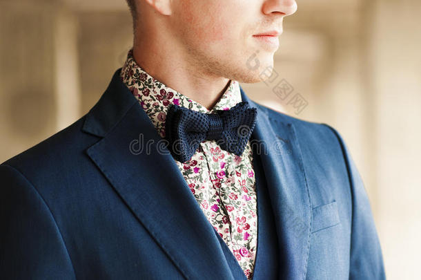 深蓝色领结，花衬衫和西装在男人的脖子上。